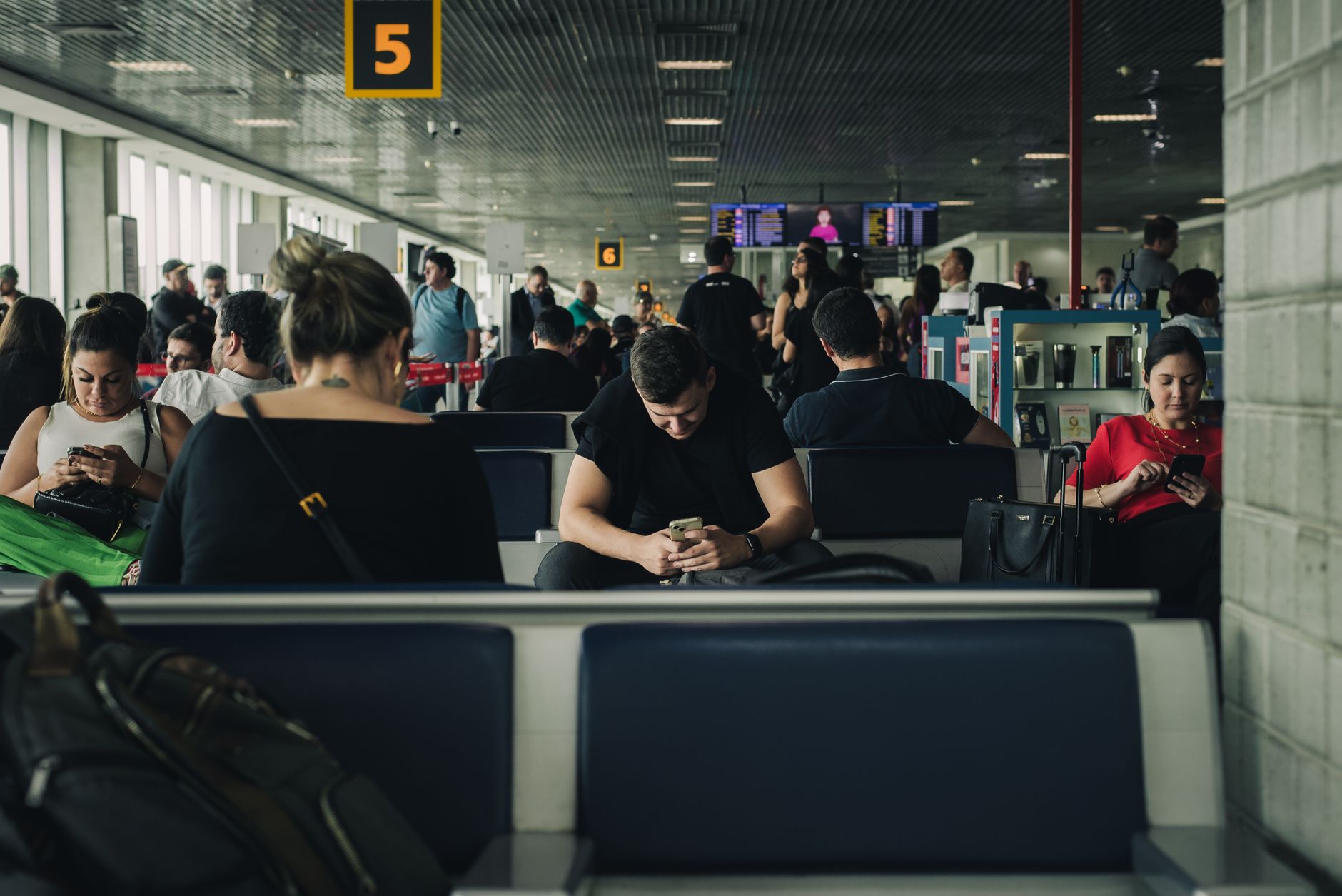 Podróżny sprawdzający status wniosku o ETA w telefonie na lotnisku